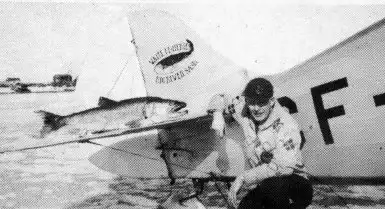 george greening, with a large lake trout on the stabilzer
<br>
 of the Waco BBQ which he flew for Waite's Fisheries