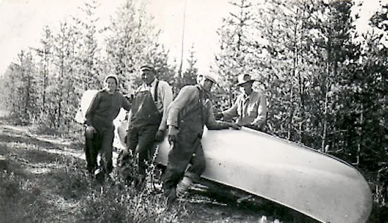 Ed theriau and Fred darbyshire portaging a canoe